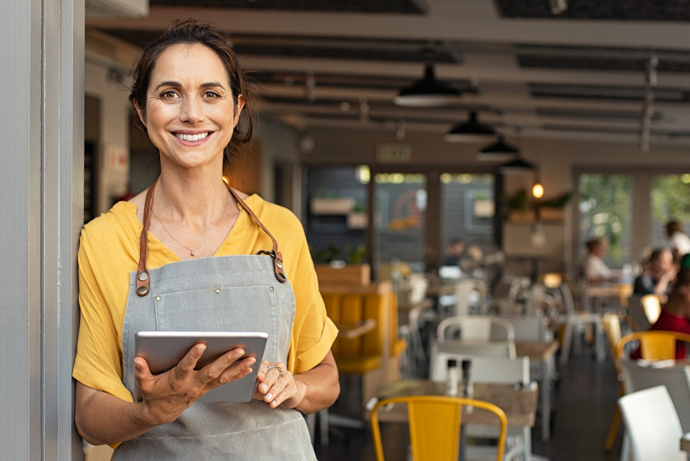 Female Worker stood in doorway with iPad